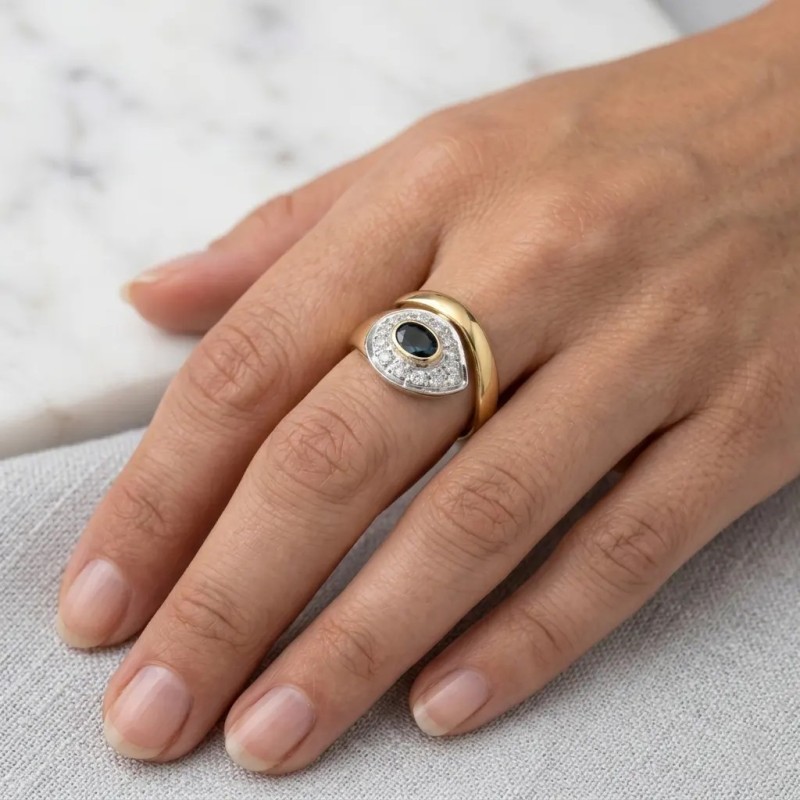Anillo bicolor de oro de 18 kt con zafiro ovalado y diamantes