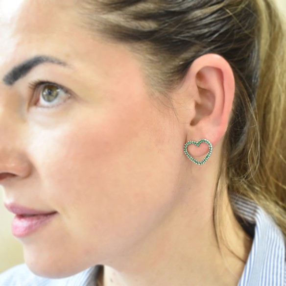 Heart earrings on the lobe with emeralds